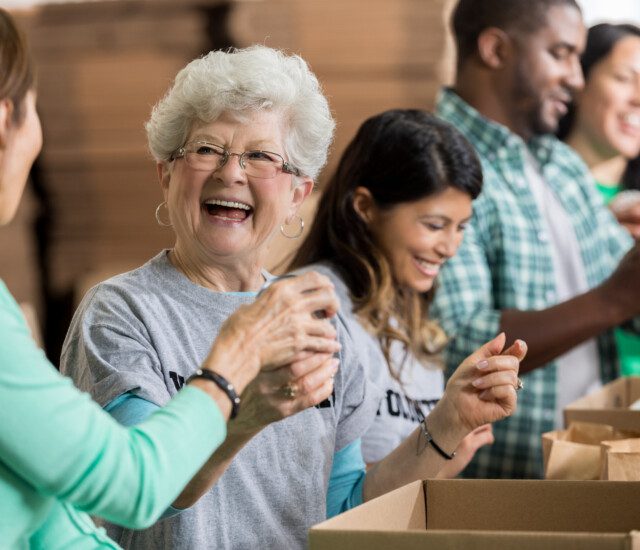 Vibrant older woman joyfully volunteers her time