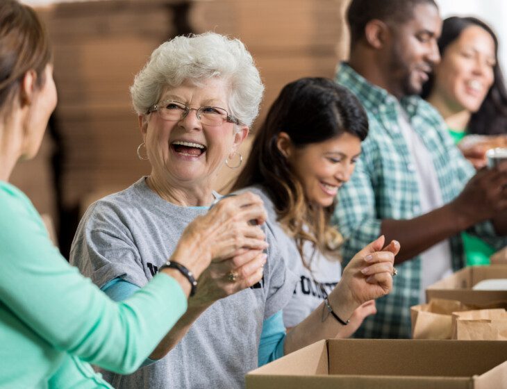 Vibrant older woman joyfully volunteers her time